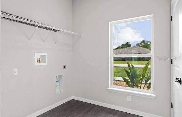 washroom with hookup for a washing machine, hookup for an electric dryer, dark wood finished floors, baseboards, and laundry area