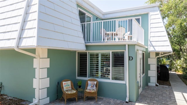 4150 S Atlantic Ave Unit 115D, New Smyrna Beach, FL 32169 - view of property exterior with stucco siding, a patio, and a balcony