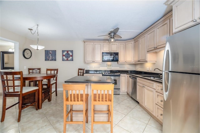 4150 S Atlantic Ave Unit 115D, New Smyrna Beach, FL 32169 - kitchen featuring stainless steel appliances, dark countertops, a ceiling fan, light tile patterned floors, and a sink