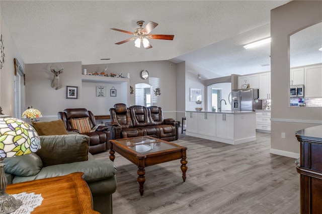 2204 Kumquat Dr, Edgewater, FL 32141 - living area with arched walkways, a textured ceiling, and lofted ceiling