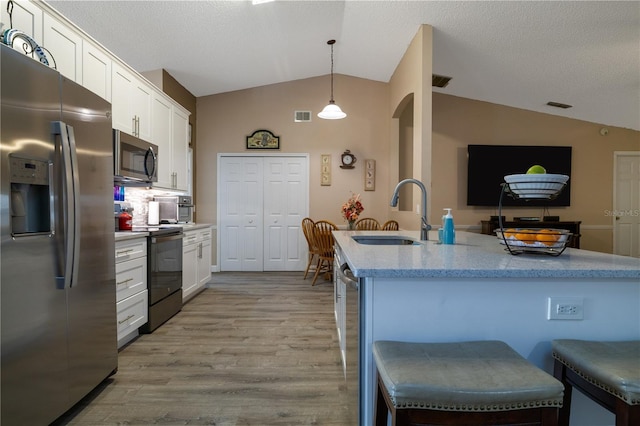 2204 Kumquat Dr, Edgewater, FL 32141 - kitchen with a sink, appliances with stainless steel finishes, vaulted ceiling, and white cabinetry