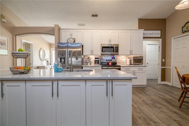 2204 Kumquat Dr, Edgewater, FL 32141 - kitchen with white cabinets, light stone counters, a sink, backsplash, and stainless steel appliances