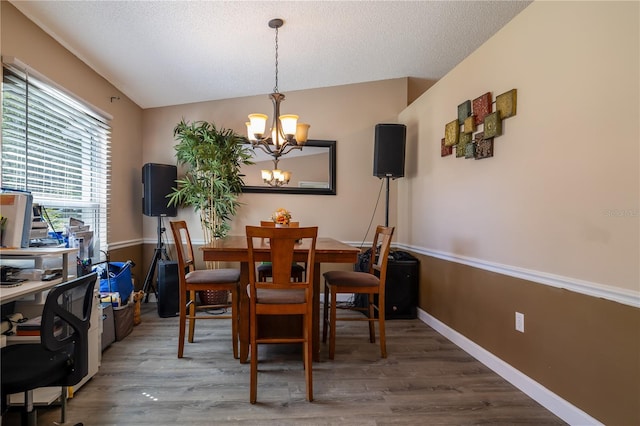 2204 Kumquat Dr, Edgewater, FL 32141 - dining area featuring an inviting chandelier, baseboards, a textured ceiling, and wood finished floors