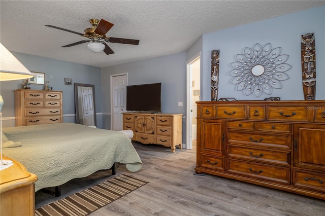 2204 Kumquat Dr, Edgewater, FL 32141 - bedroom with light wood-style floors, ceiling fan, a closet, and a textured ceiling