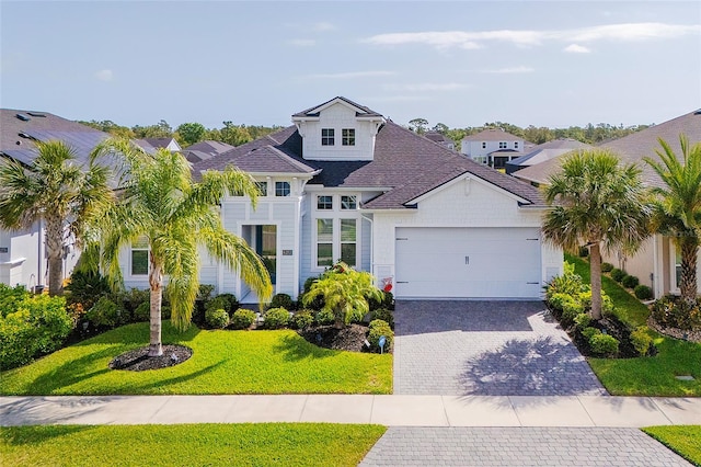 6277 W Fallsgrove Ln, Port Orange, FL 32128 - view of front of home with roof with shingles, an attached garage, a residential view, a front lawn, and decorative driveway
