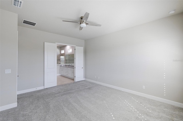 6277 W Fallsgrove Ln, Port Orange, FL 32128 - unfurnished bedroom with light colored carpet, ensuite bathroom, visible vents, and baseboards