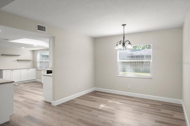3644 Dame St, Port Orange, FL 32129 - unfurnished dining area with light wood-style floors, visible vents, baseboards, and an inviting chandelier