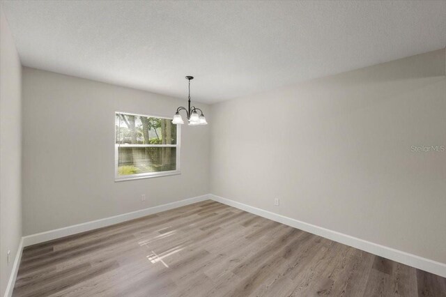 3644 Dame St, Port Orange, FL 32129 - empty room featuring baseboards, a notable chandelier, and wood finished floors