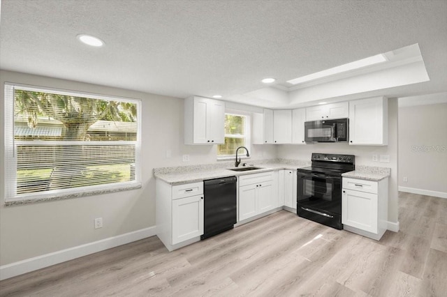 3644 Dame St, Port Orange, FL 32129 - kitchen featuring a sink, a textured ceiling, black appliances, light wood-type flooring, and a raised ceiling