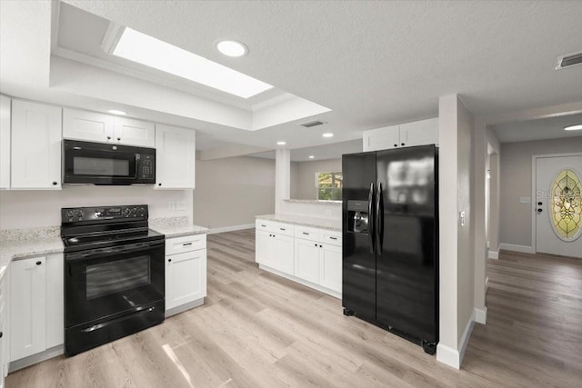 3644 Dame St, Port Orange, FL 32129 - kitchen with white cabinets, light wood-type flooring, visible vents, and black appliances
