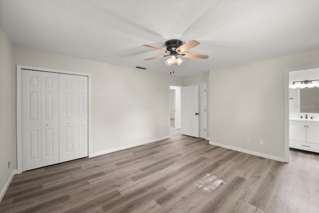 3644 Dame St, Port Orange, FL 32129 - unfurnished bedroom with baseboards, ensuite bath, wood finished floors, and a sink