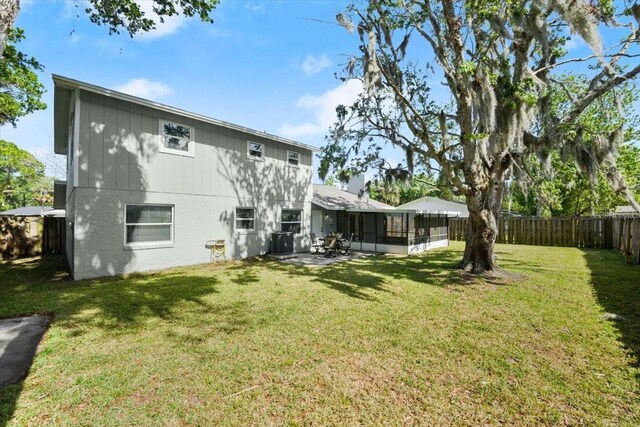 3644 Dame St, Port Orange, FL 32129 - back of house featuring cooling unit, a yard, a sunroom, and a fenced backyard