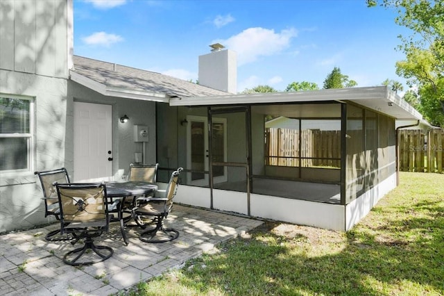 3644 Dame St, Port Orange, FL 32129 - back of property with a chimney, fence, a yard, a patio, and a sunroom