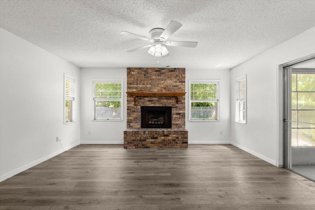 unfurnished living room featuring a healthy amount of sunlight, a textured ceiling, and dark wood-type flooring