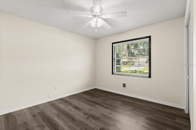 unfurnished bedroom featuring baseboards, a ceiling fan, dark wood-type flooring, and a textured ceiling