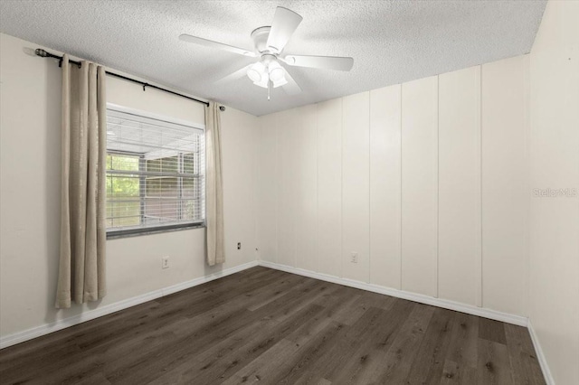 spare room featuring ceiling fan, baseboards, a textured ceiling, and dark wood-style floors