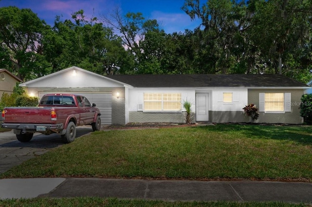 single story home featuring concrete driveway, brick siding, a front yard, and a garage