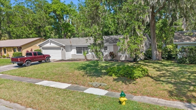 ranch-style home featuring an attached garage, a front yard, and concrete driveway