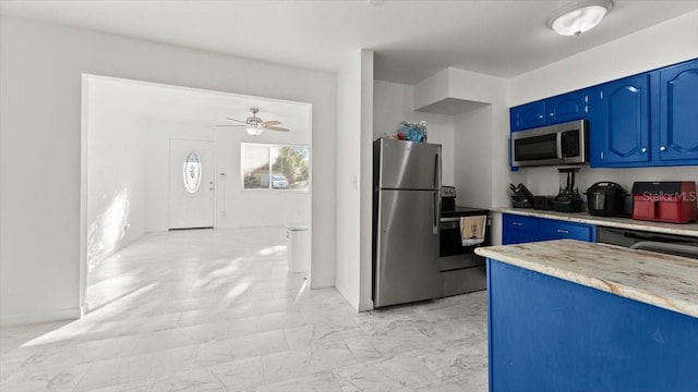 557 Berkshire Rd, Daytona Beach, FL 32114 - kitchen with stainless steel appliances, a ceiling fan, marble finish floor, and blue cabinetry