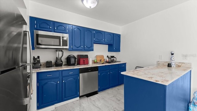 557 Berkshire Rd, Daytona Beach, FL 32114 - kitchen with light countertops, blue cabinets, marble finish floor, and stainless steel appliances