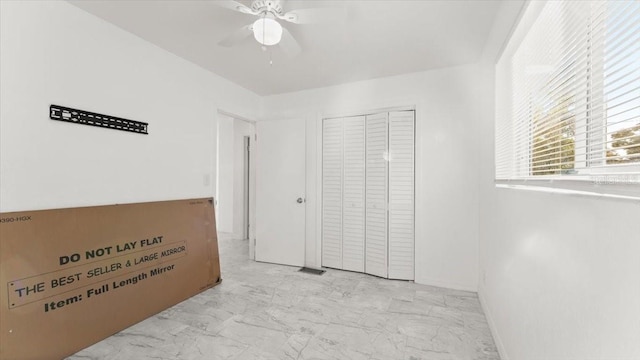 557 Berkshire Rd, Daytona Beach, FL 32114 - unfurnished bedroom featuring a ceiling fan, marble finish floor, and a closet