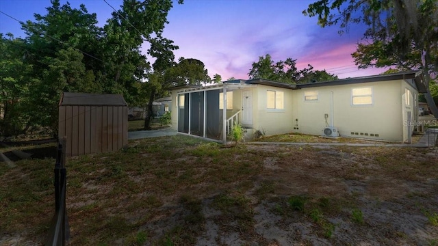 557 Berkshire Rd, Daytona Beach, FL 32114 - back of property featuring stucco siding, a shed, crawl space, an outdoor structure, and a sunroom
