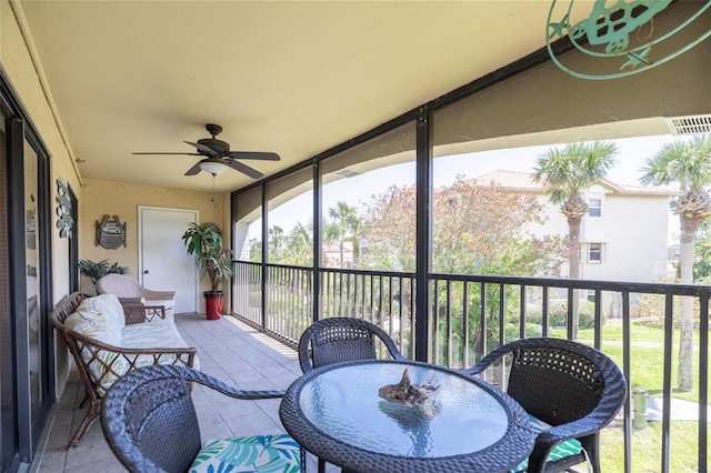 sunroom / solarium with a ceiling fan and outdoor dining area