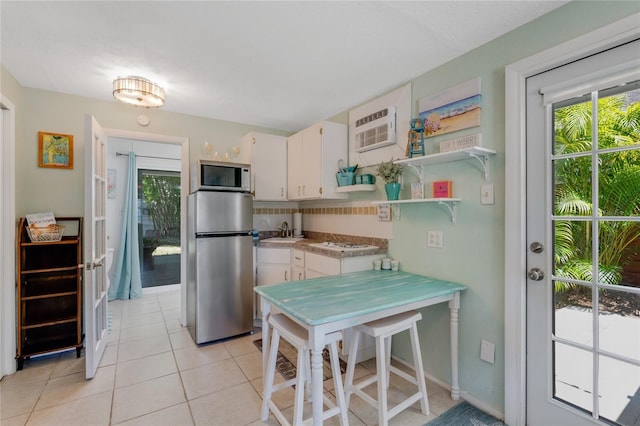 kitchen featuring open shelves, white cabinetry, a sink, appliances with stainless steel finishes, and light tile patterned floors