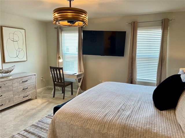 bedroom featuring baseboards and light colored carpet