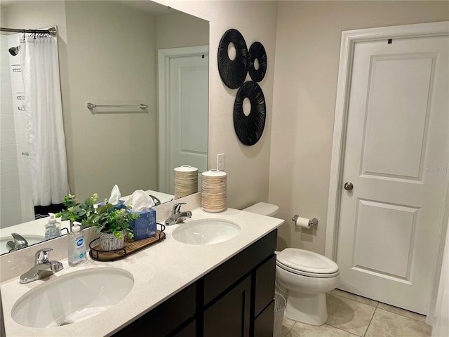 bathroom with tile patterned flooring, a sink, double vanity, and toilet