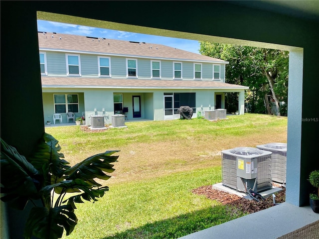 back of property with a lawn and central air condition unit