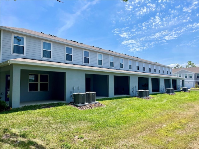 rear view of property with a lawn and central AC