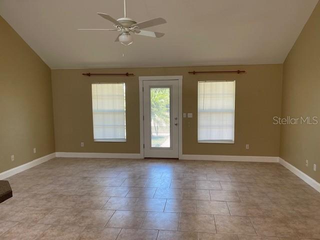 2091 Maltese Ln, New Smyrna Beach, FL 32168 - spare room featuring ceiling fan, lofted ceiling, light tile patterned floors, and baseboards