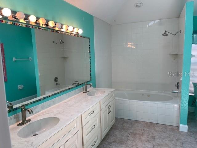 2091 Maltese Ln, New Smyrna Beach, FL 32168 - full bath featuring tile patterned flooring, a sink, tiled shower / bath, and double vanity