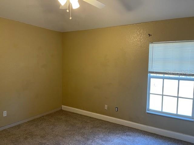 2091 Maltese Ln, New Smyrna Beach, FL 32168 - carpeted spare room with ceiling fan and baseboards