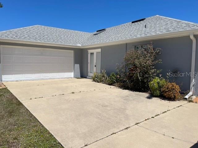 2091 Maltese Ln, New Smyrna Beach, FL 32168 - ranch-style home featuring stucco siding, driveway, a shingled roof, and a garage
