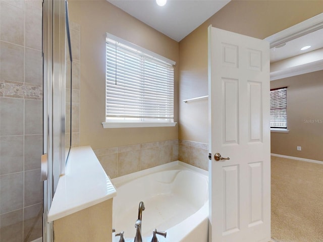 full bathroom featuring recessed lighting, a bath, and a tile shower
