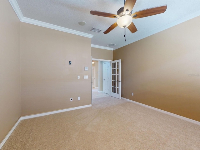 unfurnished room featuring visible vents, a ceiling fan, crown molding, and light colored carpet
