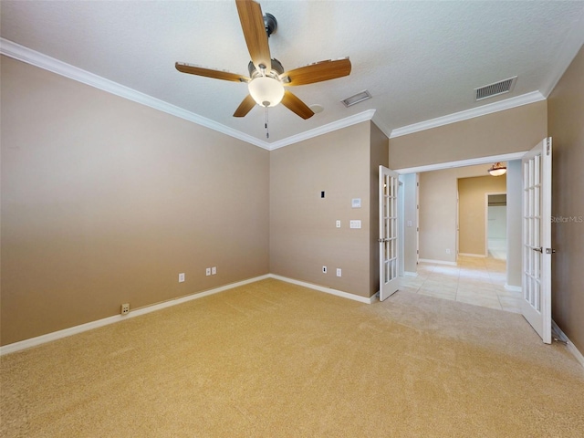 spare room featuring a ceiling fan, baseboards, visible vents, and light carpet