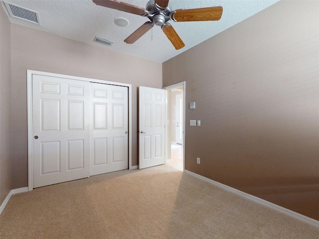 unfurnished bedroom featuring a closet, baseboards, light colored carpet, and visible vents