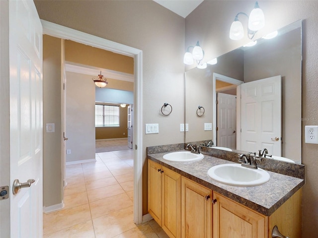 bathroom featuring a sink, baseboards, tile patterned flooring, and double vanity