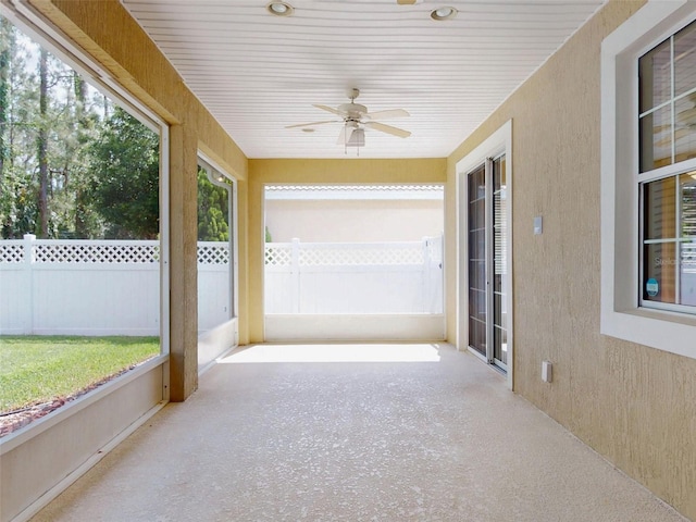 unfurnished sunroom featuring ceiling fan