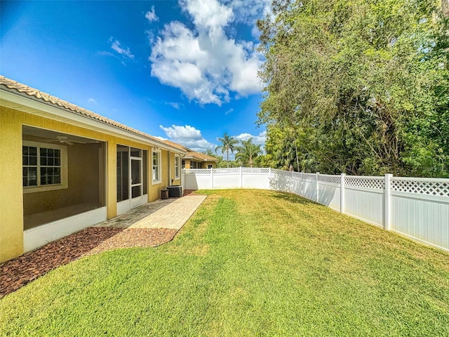 view of yard with a fenced backyard, a patio, and central AC
