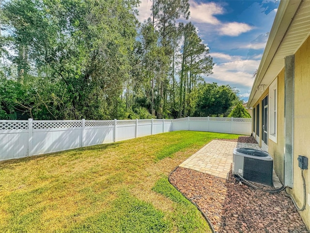 view of yard featuring central air condition unit, a fenced backyard, and a patio area