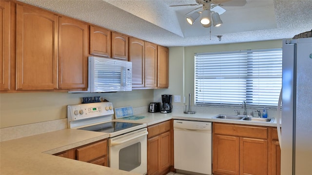 5499 Atlantic Unit 104, New Smyrna Beach, FL 32169 - kitchen with a ceiling fan, a sink, a tray ceiling, white appliances, and light countertops