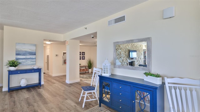 5499 Atlantic Unit 104, New Smyrna Beach, FL 32169 - foyer with a textured ceiling, visible vents, wood finished floors, and baseboards