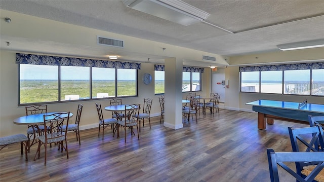 5499 Atlantic Unit 104, New Smyrna Beach, FL 32169 - recreation room featuring a textured ceiling, visible vents, wood finished floors, and baseboards