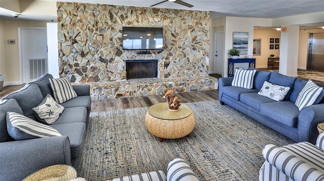 5499 Atlantic Unit 104, New Smyrna Beach, FL 32169 - living area featuring baseboards, visible vents, wood finished floors, elevator, and a fireplace