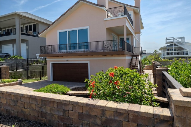 6260 S Atlantic Ave, New Smyrna Beach, FL 32169 - view of front of property with stairway, fence, an attached garage, and stucco siding