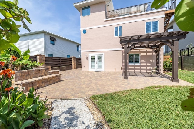 6260 S Atlantic Ave, New Smyrna Beach, FL 32169 - back of house featuring stucco siding, a pergola, a fenced backyard, a balcony, and a patio area